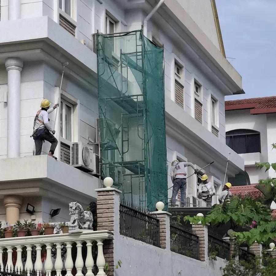 Crew repainting the exterior of a multi-storey house